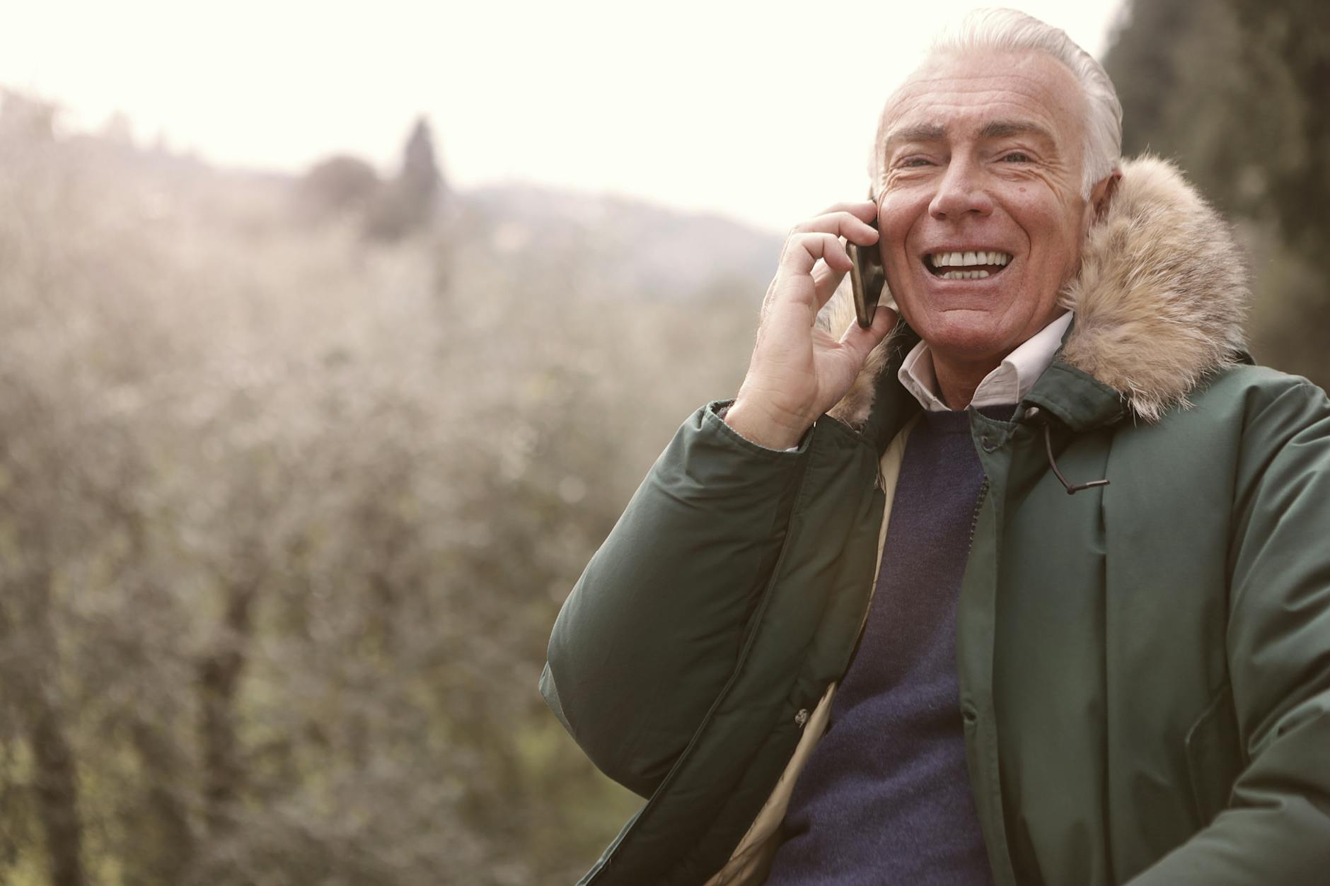 man wearing gray coat using a cellphone