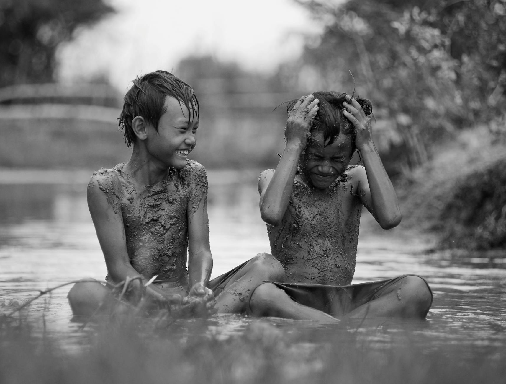 two boy playing with mud