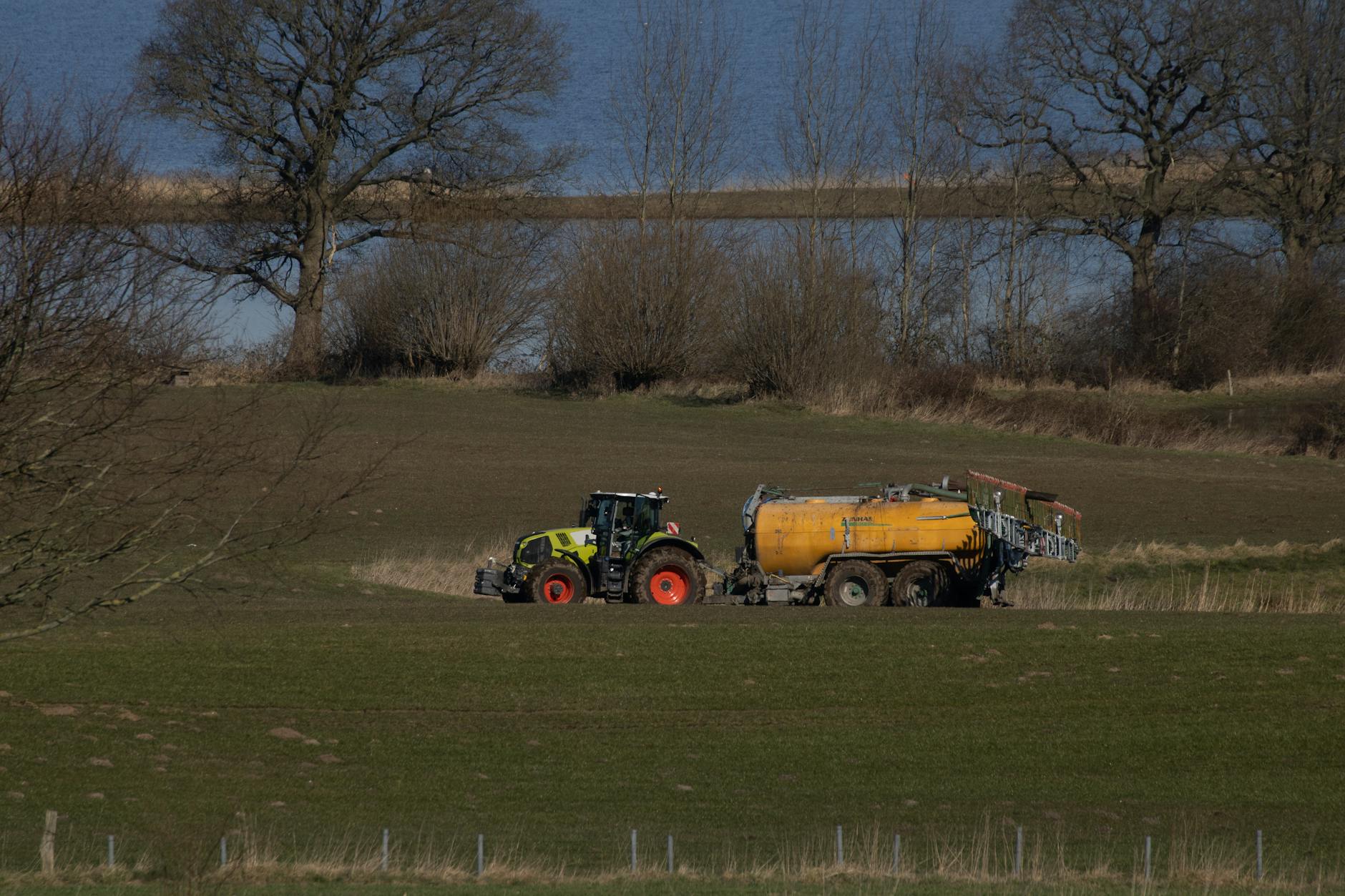 claas tractor on meadow delivering manure and got stuck