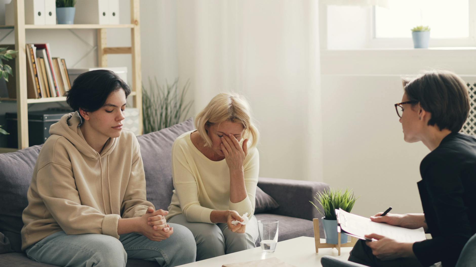 three women sitting on a couch talking to each other