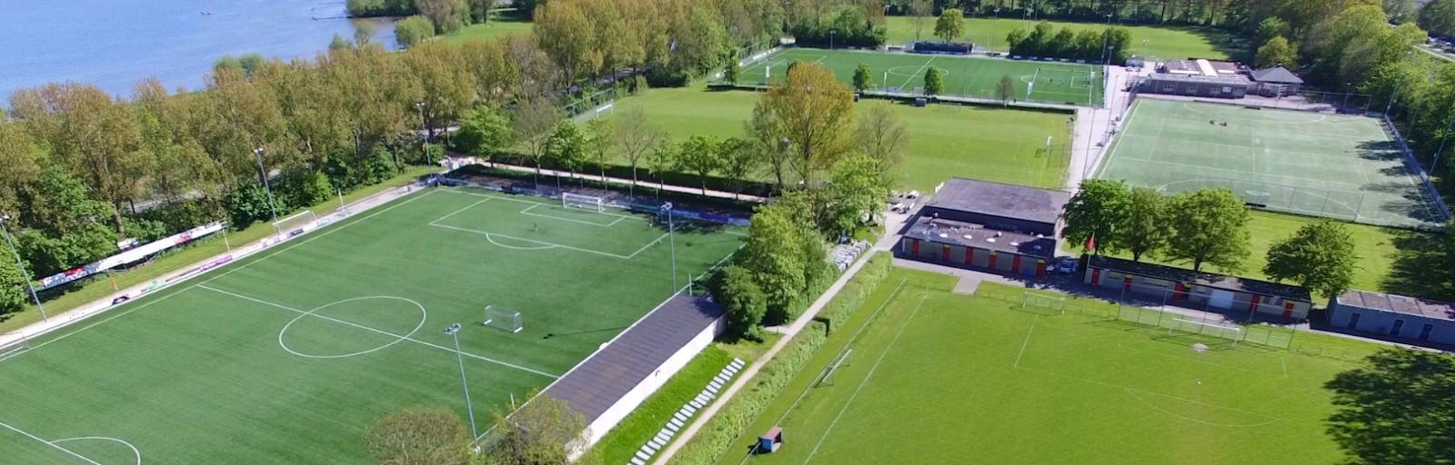 Verlichte trainingsvelden van s.v. Enkhuizen op schemeravond, symbool voor waakzaamheid en steun.