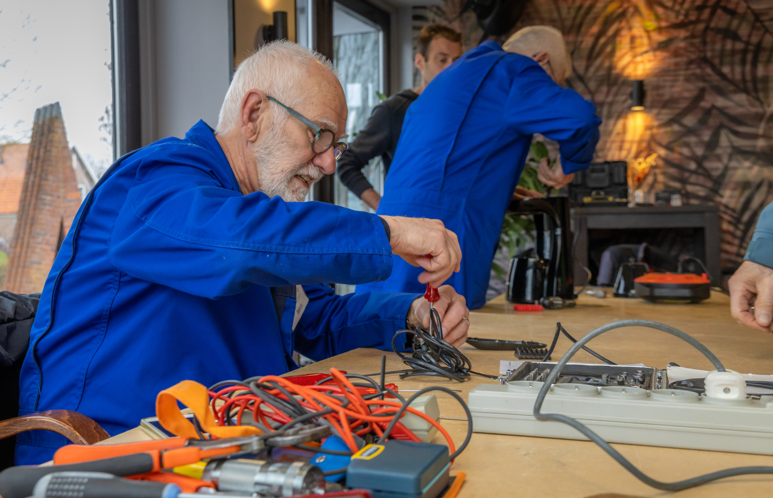 Vrijwilligers repareren huishoudelijke apparaten tijdens Repair Café in De Brink Obdam
