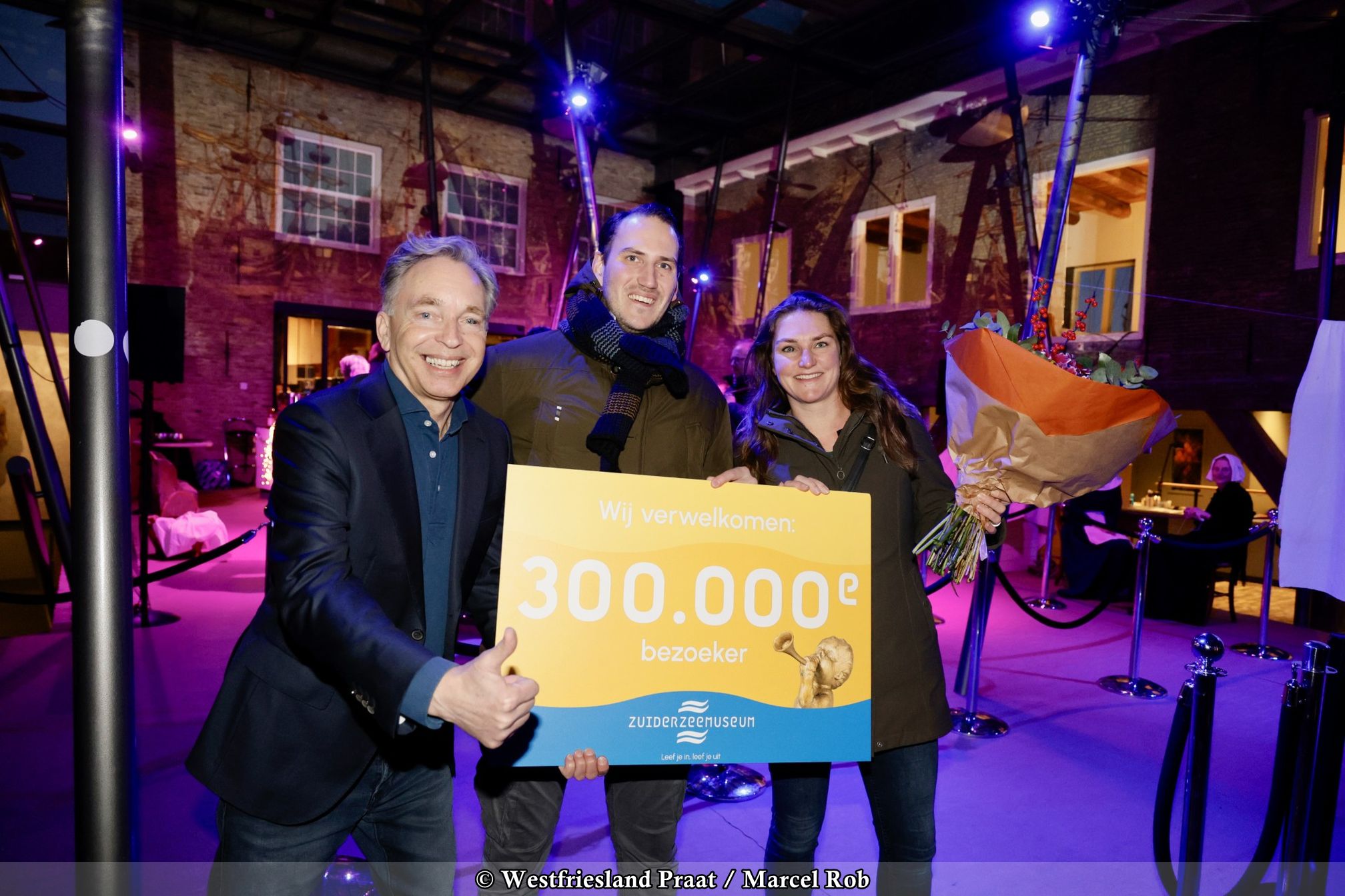 Bezoeker ontvangt bloemen bij viering 300.000ste bezoeker in het Zuiderzeemuseum in Enkhuizen.