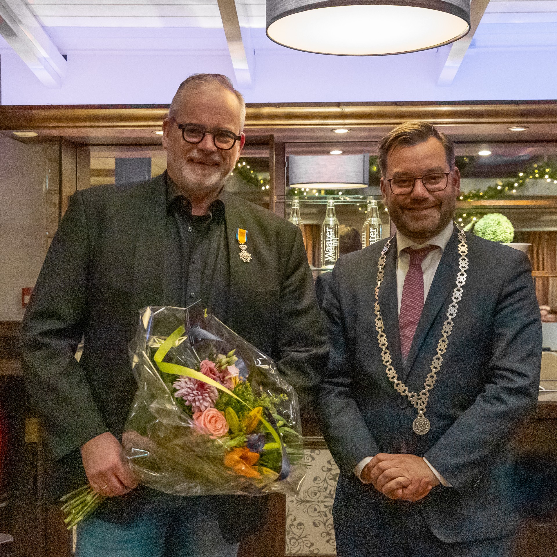 Burgemeester Michiel Pijl speldt Rolf Keur uit Andijk een lintje op