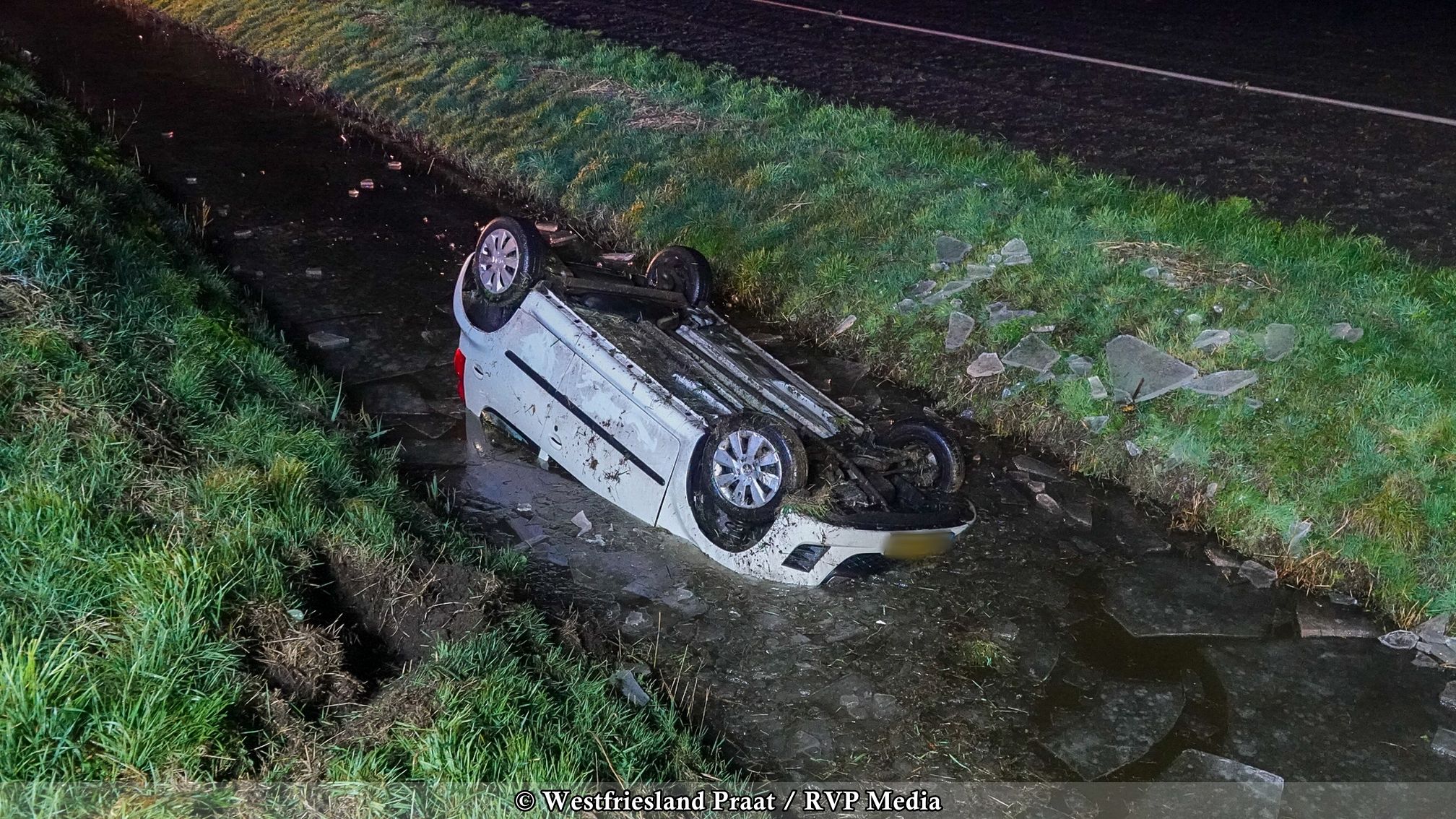 Auto ondersteboven in de sloot langs de Kapelleweg in Spierdijk na gladheid