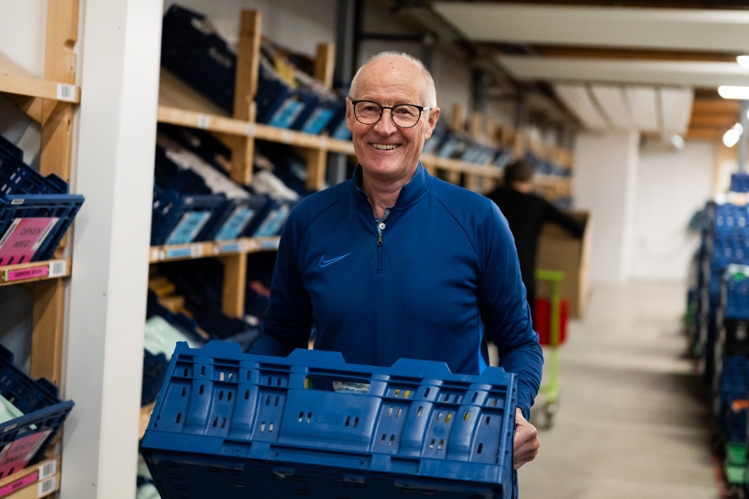 Vrijwilliger sorteert babyspullen in loods van Stichting Babyspullen in Heerhugowaard