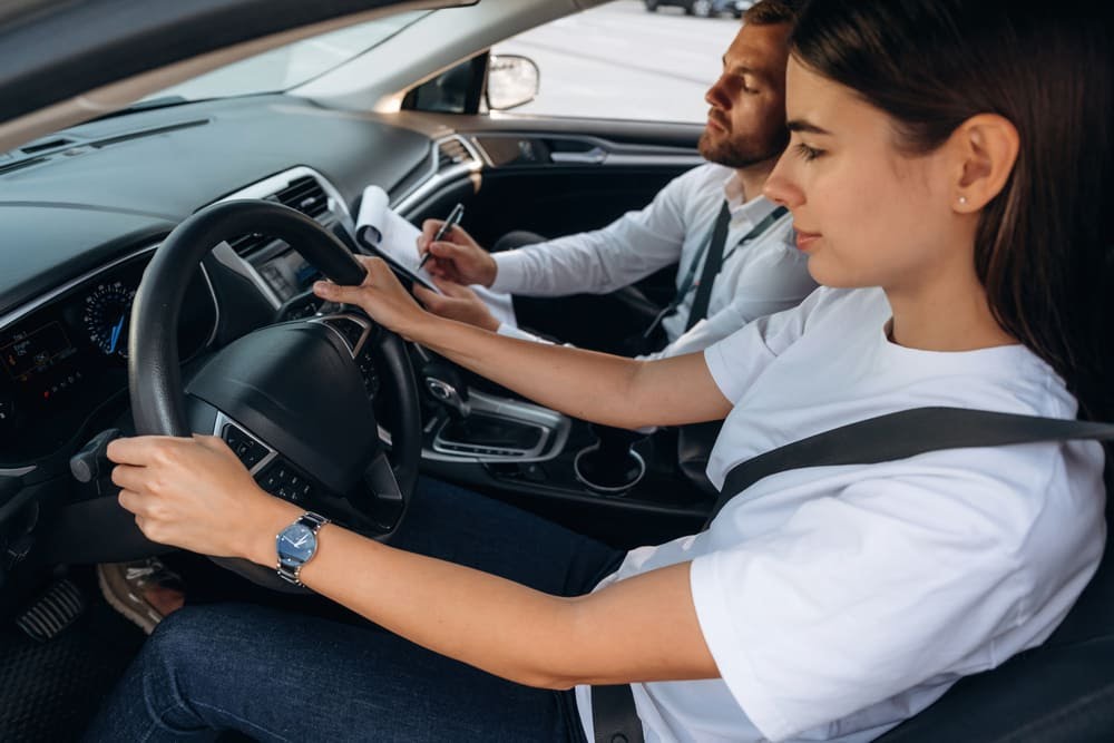 Leerling volgt rijles in automatische lesauto