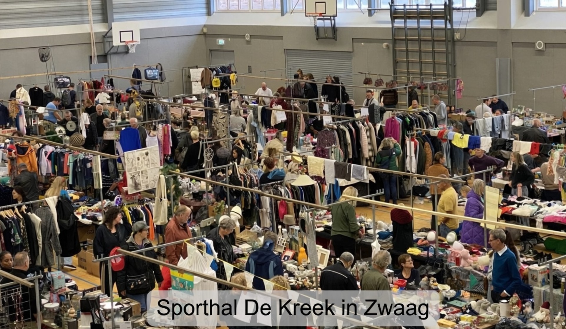 Bezoekers struinen langs kramen tijdens de Vlooienmarkt Hoorn in sporthal De Kreek in Zwaag.