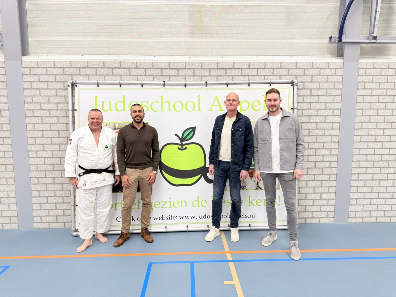 Eigenaar Steven Appels poseert met vertegenwoordigers van GlasPartners bij Judoschool Appels