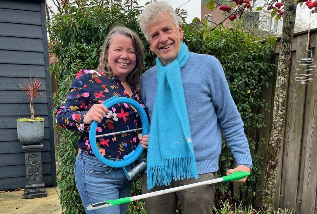 Vrijwilligers van CleanUp Hoorn ruimen zwerfafval op in een wijk van Hoorn met grijpers en vuilniszakken.