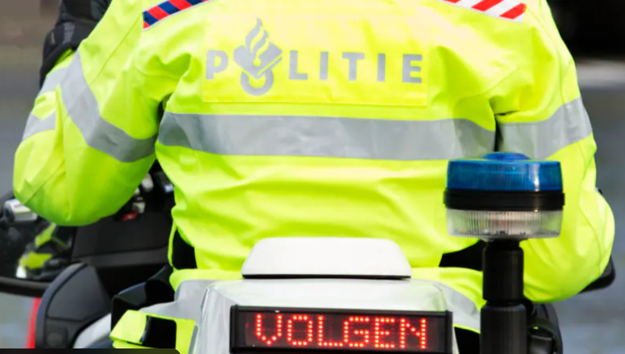 Politieagent bij verkeerscontrole op de Almereweg in Medemblik, agent controleert rijbewijs en voertuigpapieren.