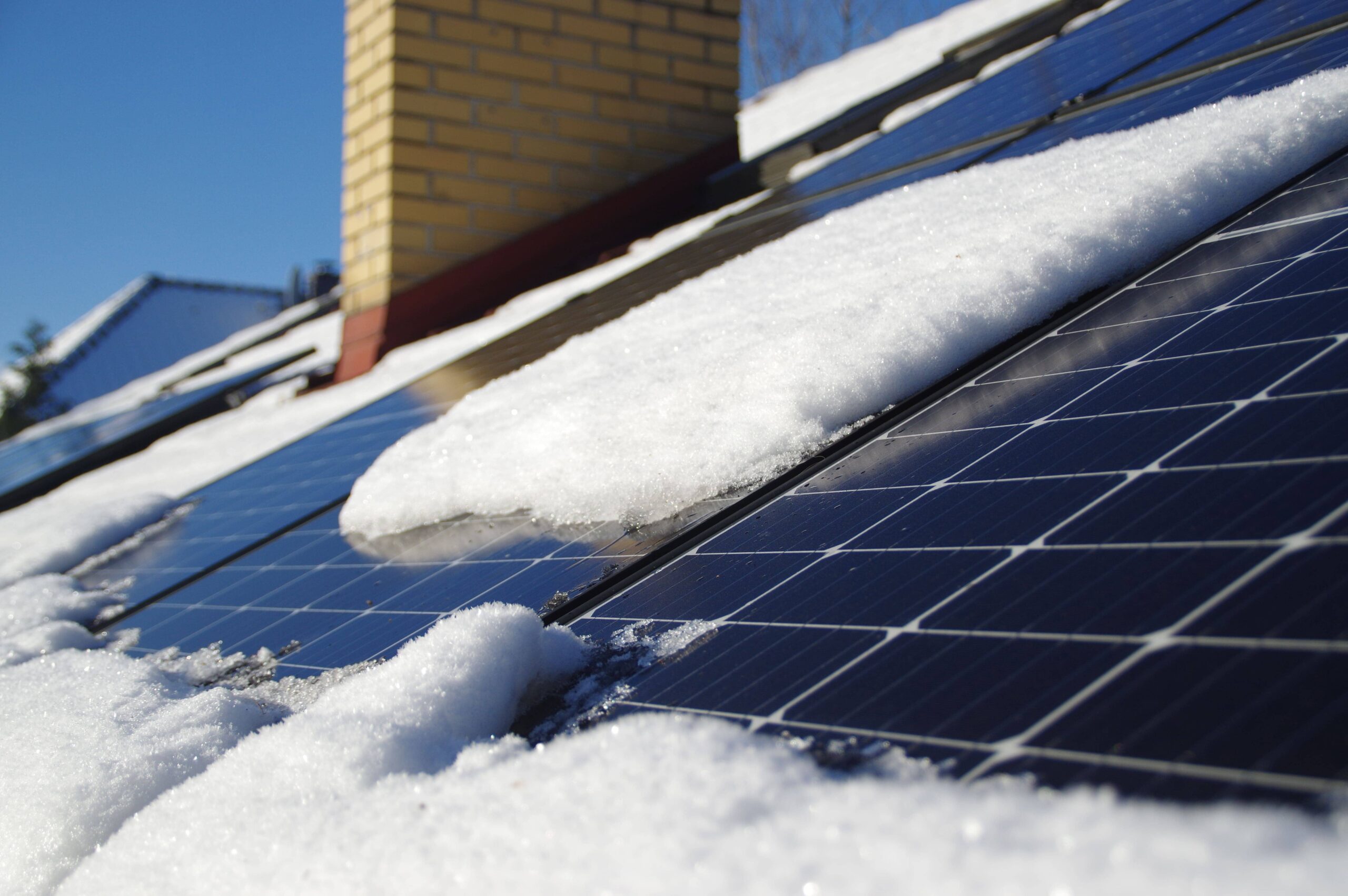 Zonnepanelen op een Nederlands dak bedekt met sneeuw tijdens winterse omstandigheden