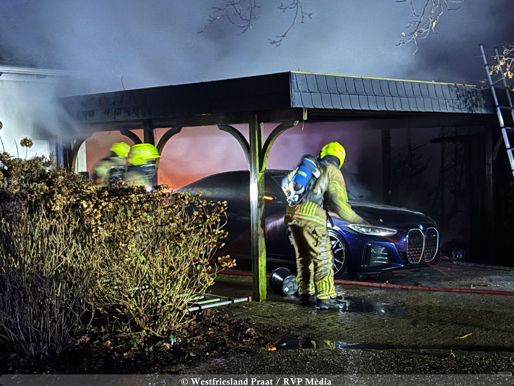 Brandweer blust autobrand onder carport bij woning aan de Lekerweg in Wijdenes