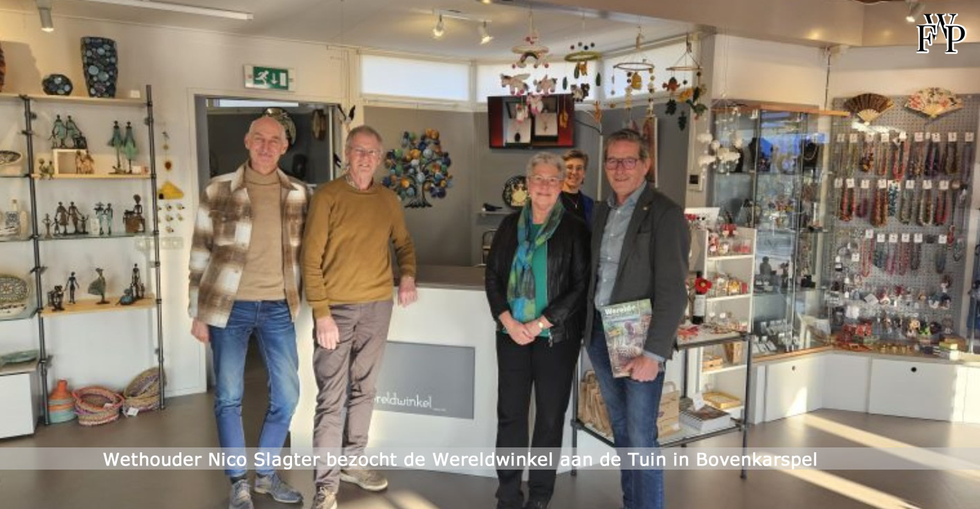 Vrijwilligers en fair trade producten in de Wereldwinkel Bovenkarspel tijdens het bezoek van wethouder Nico Slagter.