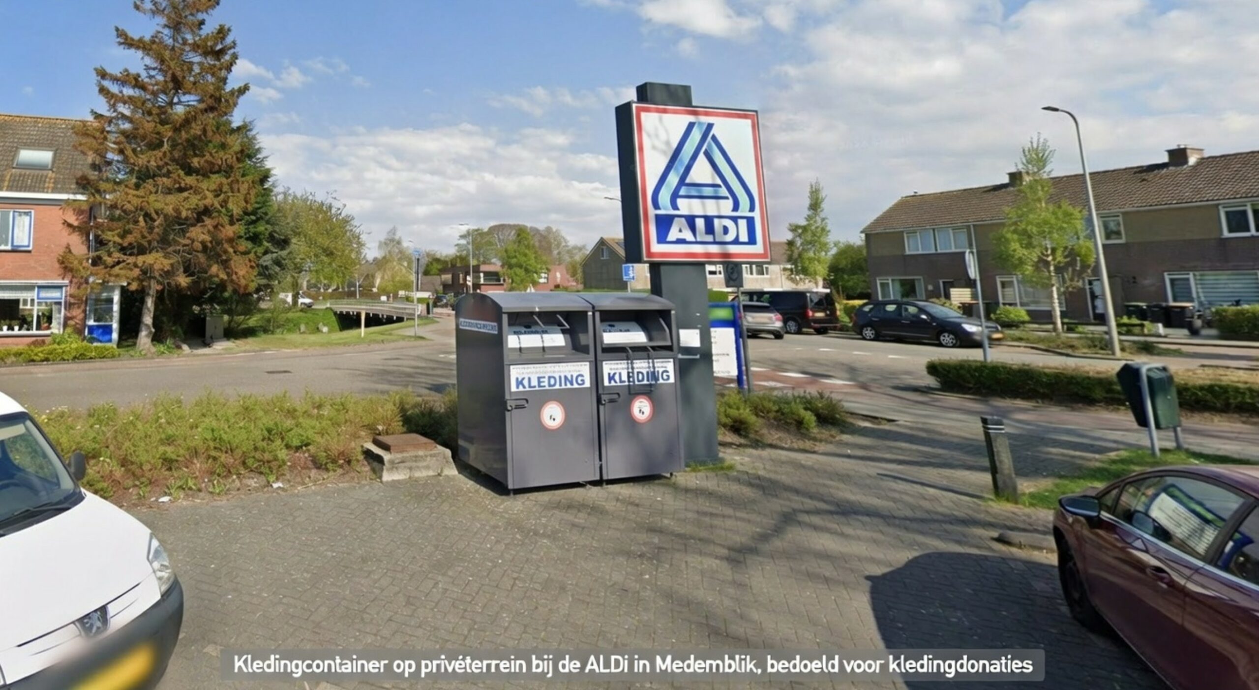 Kledingcontainer op privéterrein bij supermarkt, bedoeld voor kledingdonaties