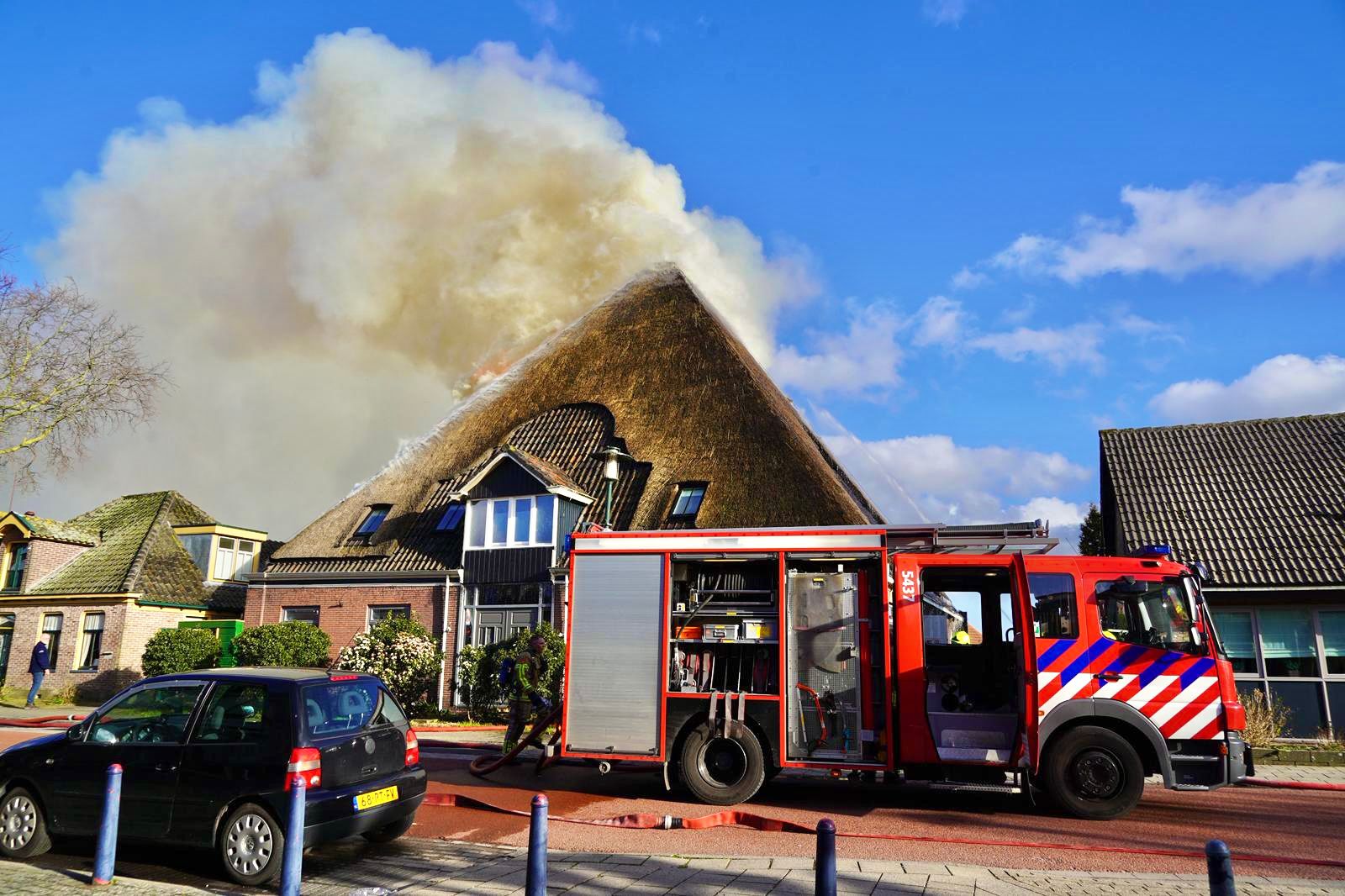 Brandweer bestrijdt grote brand in voormalige boerderij in Wervershoof met hoogwerkers