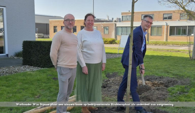 Wethouder Win Bijman plant een nieuwe boom op bedrijventerrein Krabbersplaat als onderdeel van vergroening.