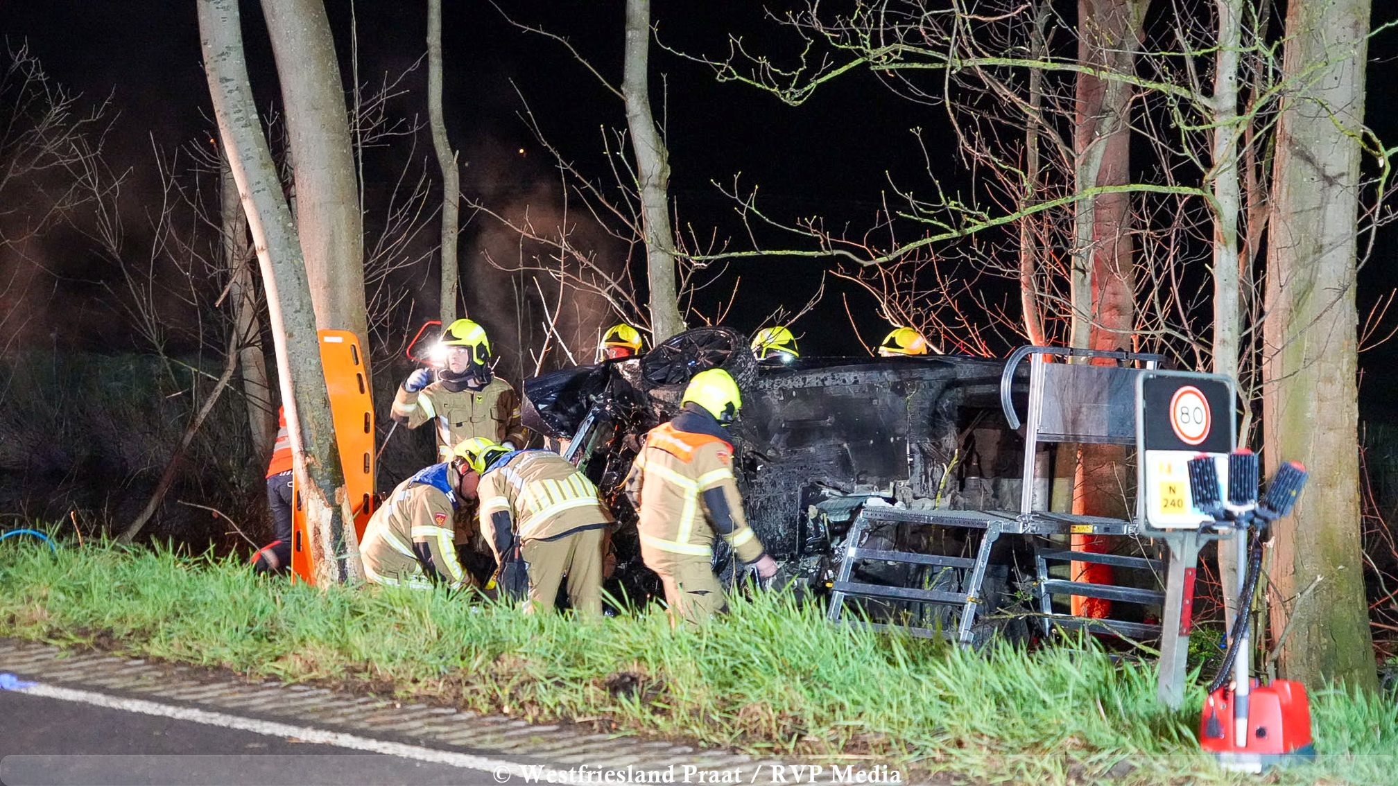 Hulpdiensten bij een zwaar ongeval op de Medemblikkerweg in Wieringerwerf, waar een auto naast de weg op zijn kant tot stilstand kwam.