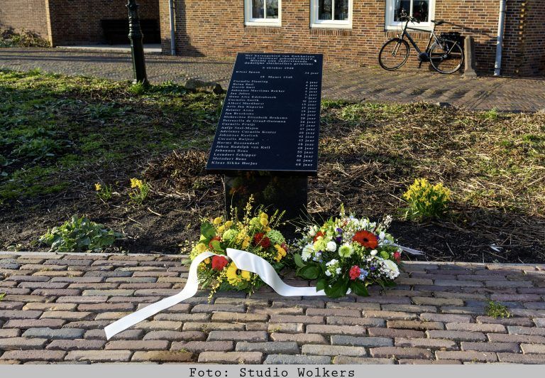 Burgemeester Jeltje Hoekstra-Sikkema legt samen met wethouder Wim Hoogervorst en kinderburgemeester Otto Schuit bloemen bij de gedenksteen op het Landje van Top in Enkhuizen.