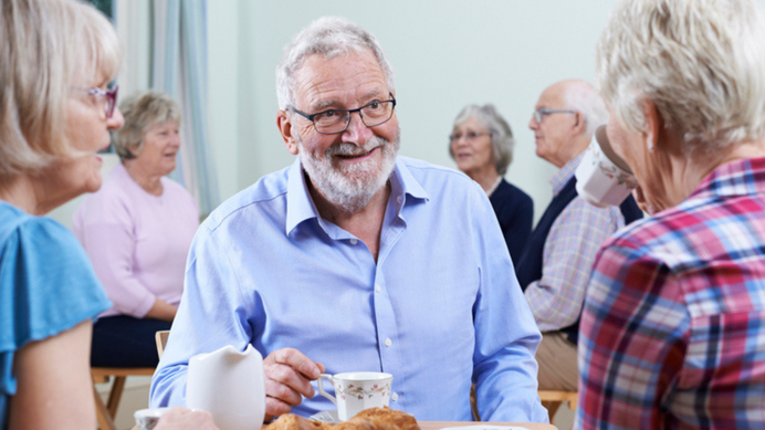 Bezoekers zitten samen aan tafel in een laagdrempelige ontmoetingsruimte in Wognum of Andijk.