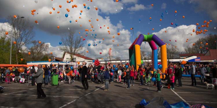 Verkeersregelaars begeleiden bezoekers tijdens Koningsdag op het Beursplein in Blokker.