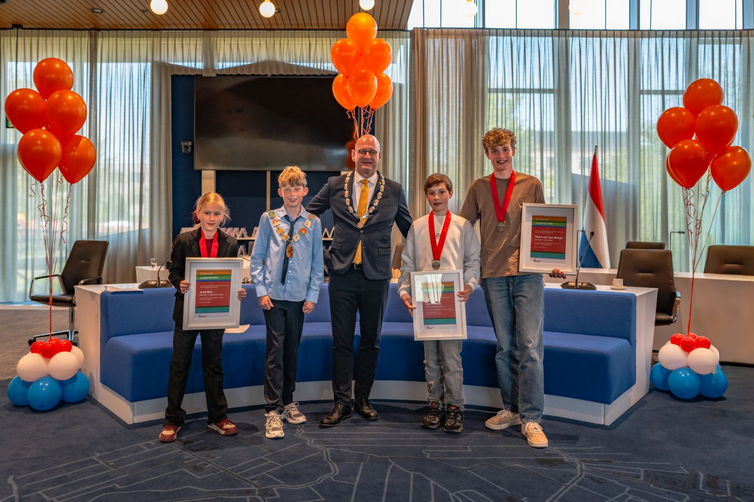 Burgemeester Jan Nieuwenburg reikt jeugdlintjes uit aan Mees van den Bergh, June Bos en Cas Blanken in Hoorn.