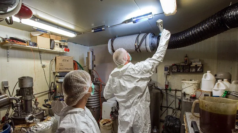 Politie-afzetting bij een appartementencomplex na de ontdekking van een illegaal drugslab in een woonwijk.