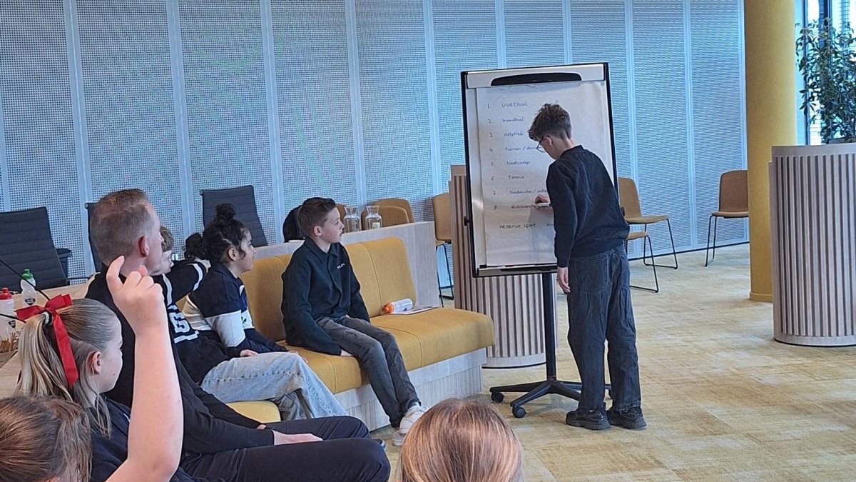 Leden van de Kinderraad Koggenland vergaderen in de raadszaal.